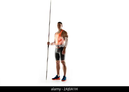 Male athlete practicing in throwing javelin isolated on white background. Professional sportsman, thrower posing confident. Concept of healthy lifestyle, movement, activity, competition. Copyspace. Stock Photo