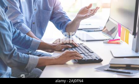 Young startup Programmers Sitting At Desks Working On Computers screen for Developing programming and coding to find solution to problem on New Applic Stock Photo