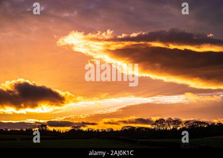 December sunset with glowing clouds and blue sky. Stock Photo