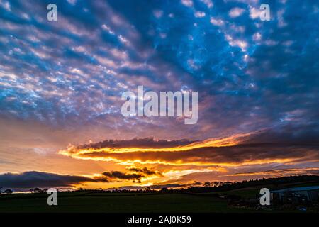 December sunset with glowing clouds and blue sky. Stock Photo