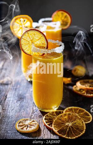 Fresh orange juice. Photo on the old table. Drinking in a smoky background. Delicious drinks and food Stock Photo