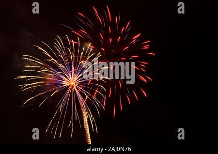 vibrant and multi-colored fireworks display against black sky Stock Photo