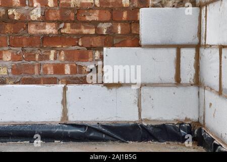 An inner block wall being constructed alongside the outer brick wall at a property in the UK Stock Photo