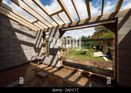 The timber roof structure casting shadows on a rear extension project at a house in Cheshire UK Stock Photo