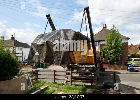 A skip being collected from a residential property in Cheshire UK Stock Photo