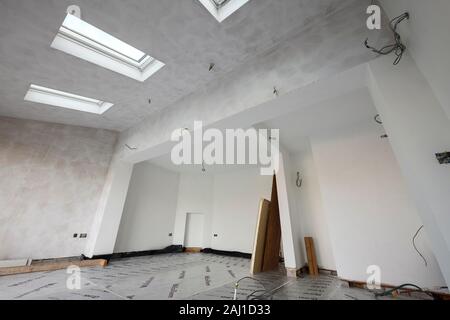 A white mist coat of paint on freshly plastered walls in a rear extension project at a house in Cheshire UK Stock Photo