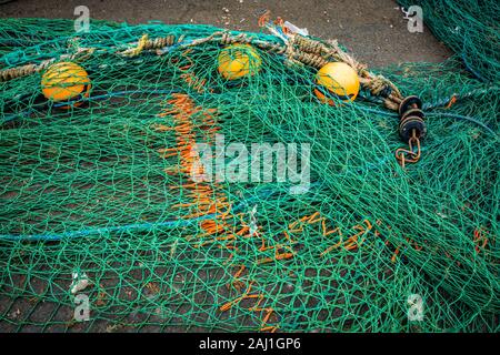 Pile of commercial fishing nets, with white floats, on the