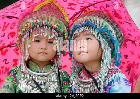 Hmong children under umbrella in the monsoon (rainy) season, Sapa, Vietnam, Indochina, Southeast Asia, Asia Stock Photo