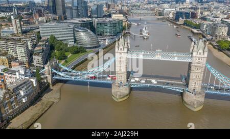 London Tower Bridge with Red buses traveling in traffic Stock Photo