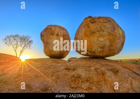 Sunset light rays at Devils Marbles, the Eggs of mythical Rainbow Serpent, at Karlu Karlu (Devils Marbles) Conservation Reserve, Australia Stock Photo