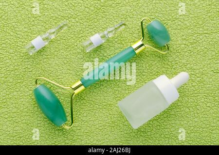 jade facial roller and face serum in ampoules and bottle Stock Photo