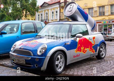 Uzhhorod, ukraine - 14 JUL, 2013: Red Bull mini cooper publicity car with a can of energy drink behind. fancy car tuning used for promotion. wet adver Stock Photo