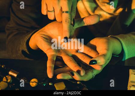 palm reading - Fortune and future teller - Palmistry fortune teller reads lines on man hand or palm to tell his future Stock Photo