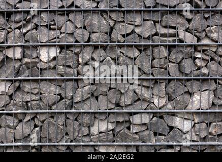 Rubble stone in steel net wall. Texture background. Stock Photo