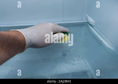 Hand cleaning inside of refrigerator. Stock Photo