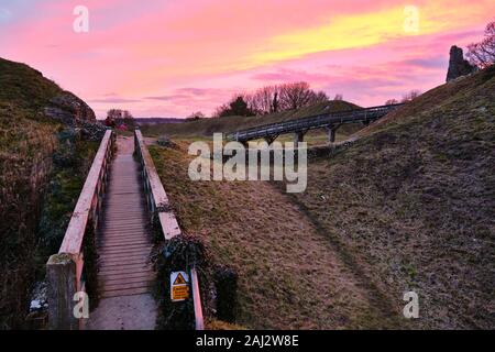 Dramatic vivid December sunset over the 11th century ruins of the Castle Acre fortifications in Norfolk England