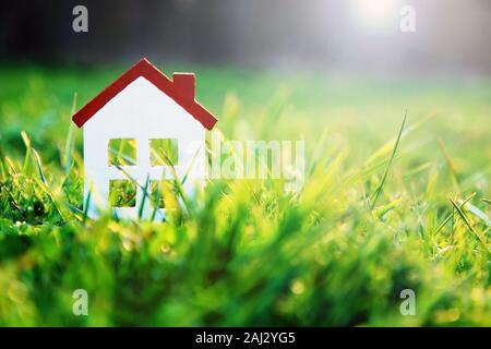 Small house in green grass on sunny day Stock Photo