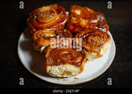 Top view of five homemade sticky buns in dark background Stock Photo
