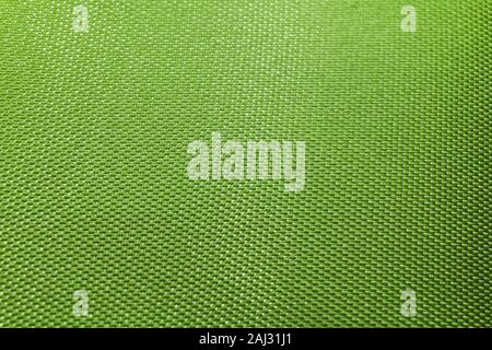 Close-up of abstract flat green high detail textured clothing fabric pattern background in partial focus and realistic light reflections Stock Photo
