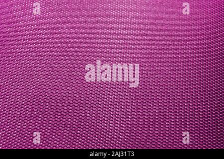 Close-up of abstract flat purple high detail textured clothing fabric pattern background in partial focus and realistic light reflections Stock Photo