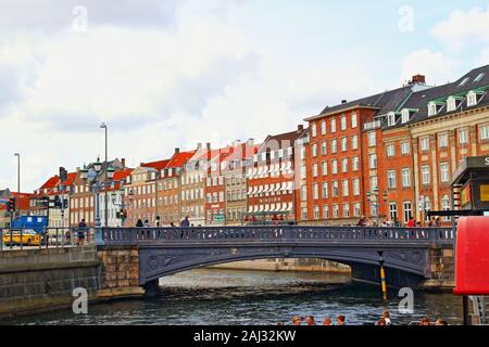 Sightseeing tour boats on a Slotsholmen canal and  Gammel Strand street lined by a row of brightly coloured old houses in downtown Copenhagen,Denmark Stock Photo