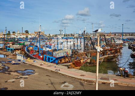 Port of Essaouira in Morocco with local fishing boats, seagulls and fishing nets on a sunny day soft focus Stock Photo