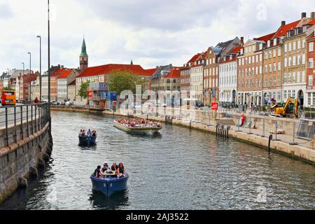 Sightseeing tour boats on a Slotsholmen canal and  Gammel Strand street lined by a row of brightly coloured old houses in downtown Copenhagen,Denmark Stock Photo