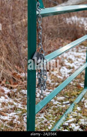 Burlington, Ontario, Canada, January 2 2020: Green opened fence with padlock and chain hanging on one side Stock Photo