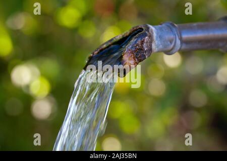 Closeup of water running from outdoor wall faucet Stock Photo