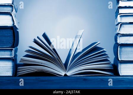 A simple composition from many hardback books, tinted in classic blue color, 2020 trend. I'm going back to school. Copy space Education Stock Photo