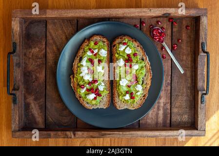 Avocado sandwich on sliced bread toast made with pomegranate and feta cheese Stock Photo