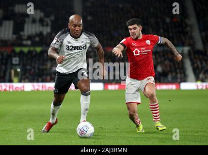 Derby County's Andre Wisdom (left) and Barnsley's Alex Mowatt battle for the ball during the Sky Bet Championship match at Pride Park, Derby. Stock Photo