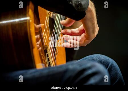 Hand of an artist playing classical guitar. Close-up shot, selective focus Stock Photo