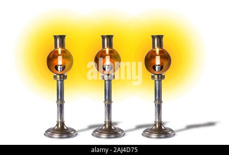 Antique spring loaded candlesticks made around 1900 with glow of burning candle. Stock Photo