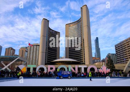 Ice cleaning machine on skating rink in front of Iconic Toronto sign at New City Hall. Low angle looking up.  Toronto Canada. Stock Photo