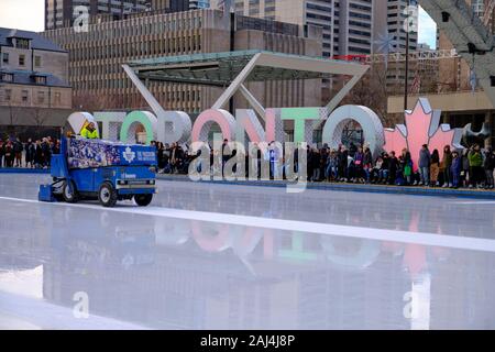 in movement Ice cleaning machine on skating rink in front of Iconic Toronto sign at New City Hall.  Toronto Canada. Stock Photo