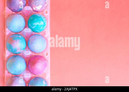 Painted Easter eggs with space intergalactic pattern in stand on coral background Stock Photo