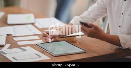 Cropped shot of young professional ux web developer working on her project while using digital tablet Stock Photo