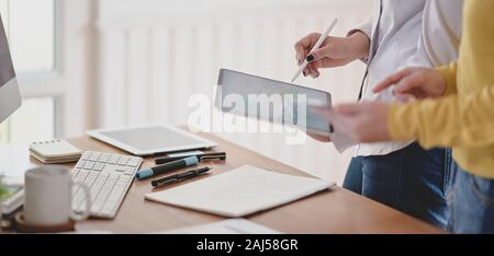 Cropped shot of young professional ux web developer working on her project while using digital tablet Stock Photo