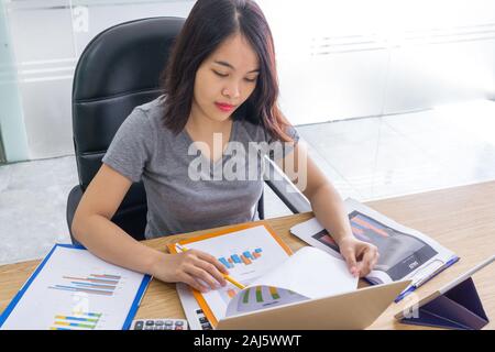 Office lady analyzing graphs on sales reports Stock Photo
