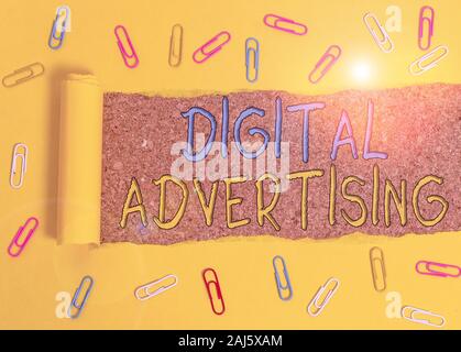 Text sign showing Digital Advertising. Business photo text marketing of products or services using internet Paper clip and torn cardboard placed above Stock Photo