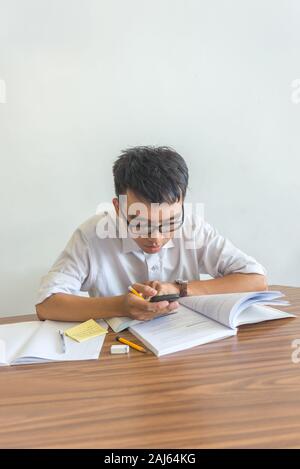 Vertical photo of young male student using smartphone Stock Photo