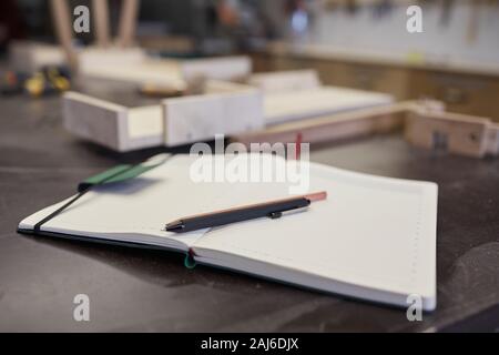 Close-up of opened note pad with pen and pensil on it on the table at office Stock Photo