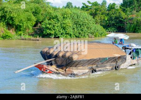 Mekong Delta, Vietnam; May 26, 2011. Boat carrying rice husks passing through the Mekong Delta. Stock Photo