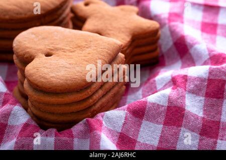 Preparation for the holiday. Baked gingerbread cookies for the new year. Gingerbread blanks before drawing. Gingerbread cookies with holes for hanging Stock Photo