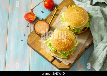 American snack Street food. Fast food. Homemade hamburger on wooden rustic table. Free space for your text. Stock Photo