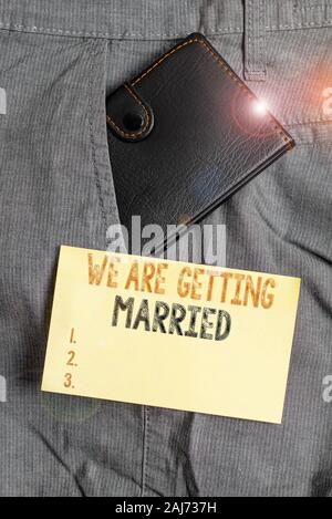 Writing note showing We Are Getting Married. Business concept for Engagement Wedding preparation Loving couple Small wallet inside trouser front pocke Stock Photo