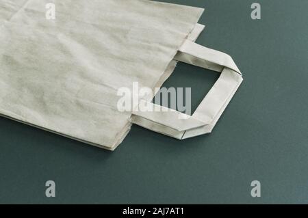 Recyclable paper shopping bag on dark green eco paper background Stock Photo