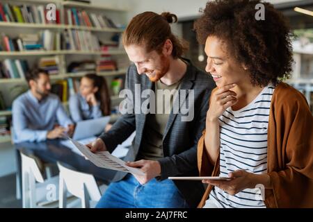 Happy young business people colleagues talking working in office Stock Photo