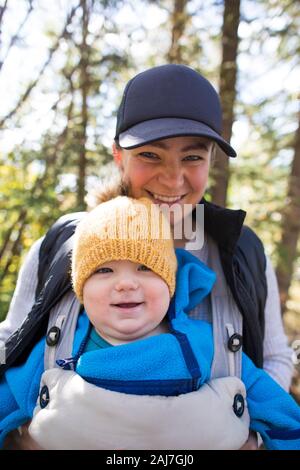 Portrait of mother with baby in front carrier. Stock Photo